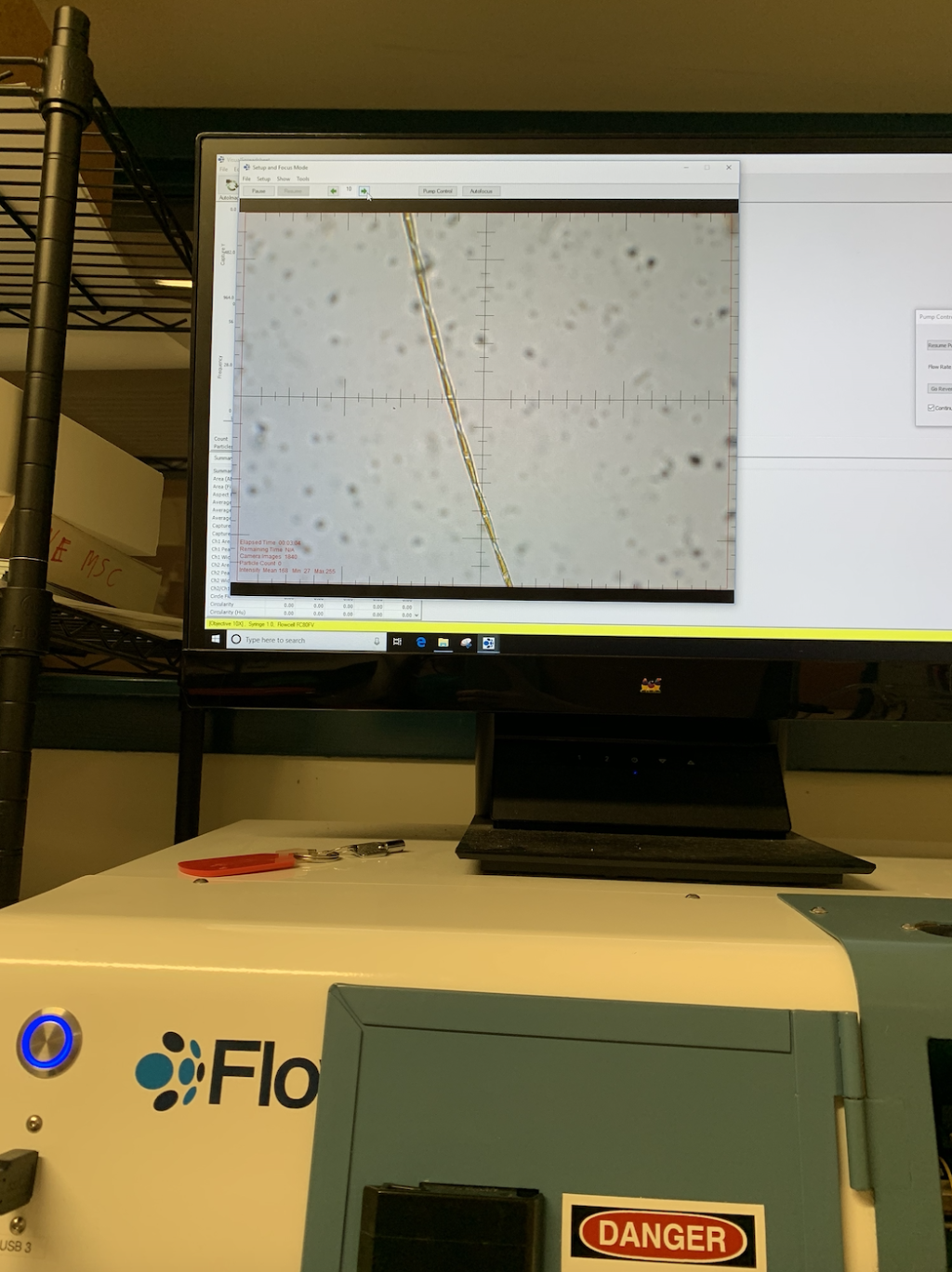 Photo of microscope with Pseudonitzschia sp. phytoplankton shown