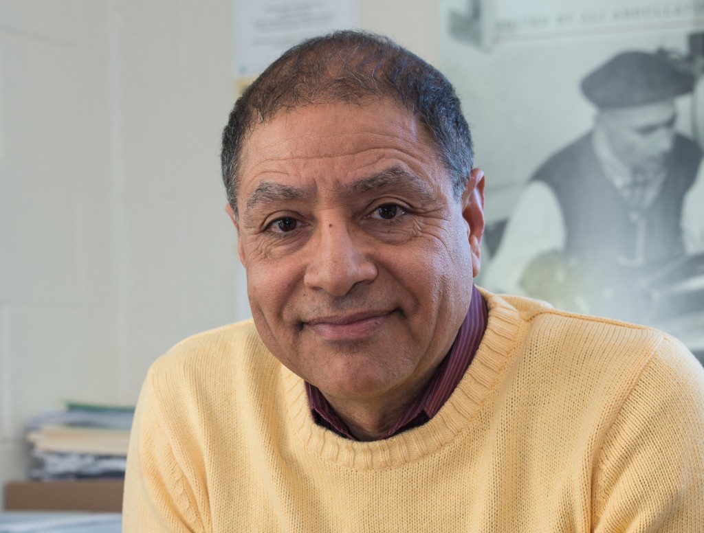 Portrait of man in yellow sweater smiling at camera