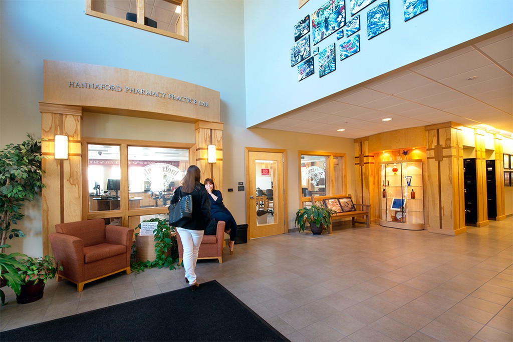 A woman walks through the interior entrance to the School of Pharmacy building