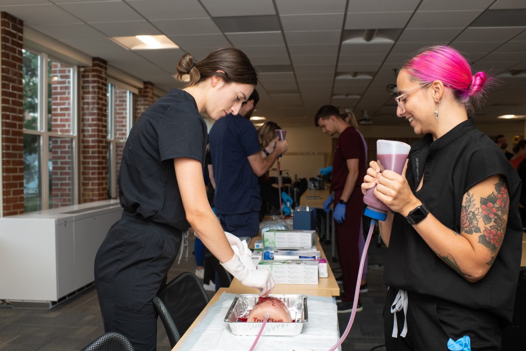 PA students use gauze to stop an artificial bleed. 