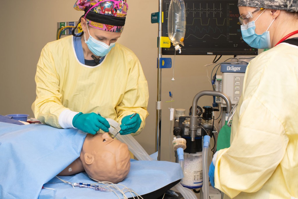 Two Nurse Anesthesia students practicing giving anesthesia on a patient simulator