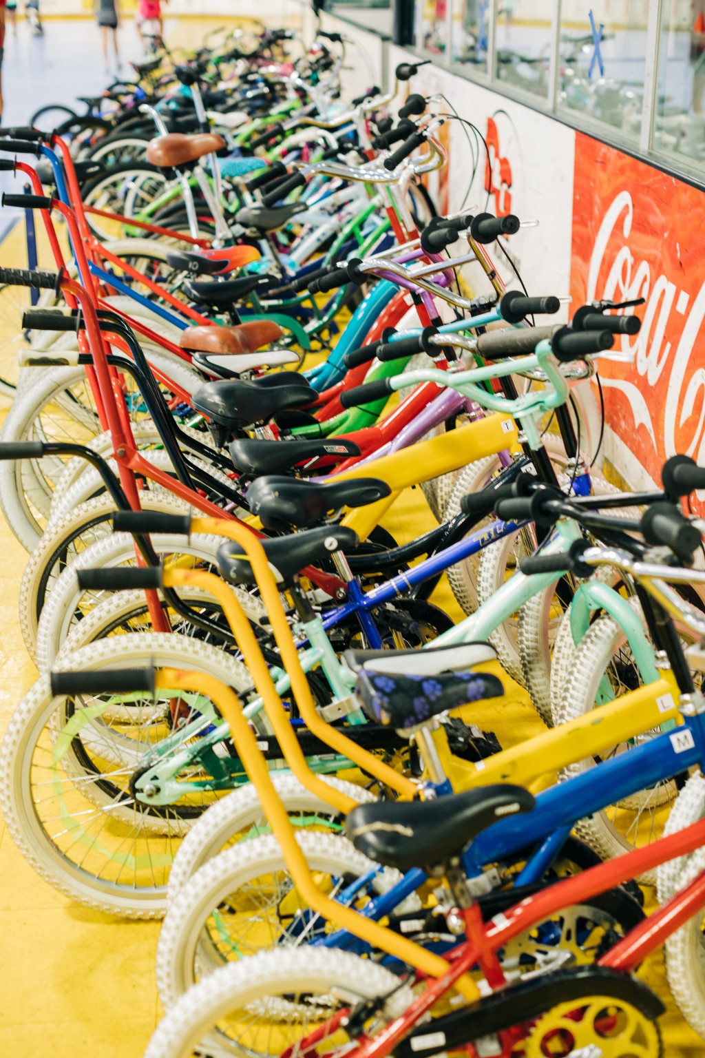 Bikes of various colors are lined up in a row