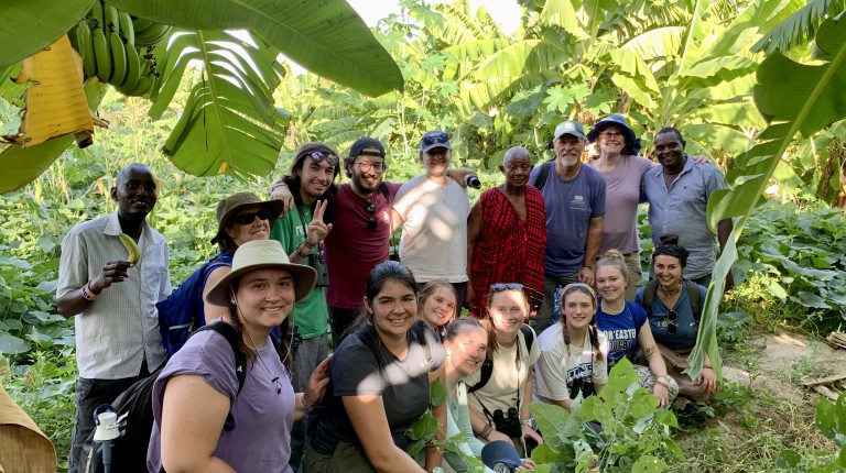 A group of U N E students and guides pose in a jungle in Kenya