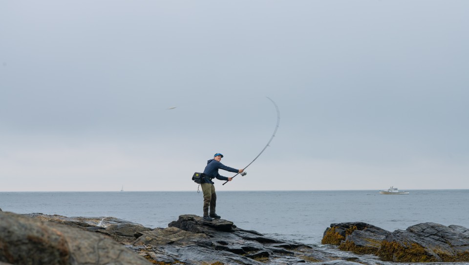 A UNE student fishes off the coast of Biddeford