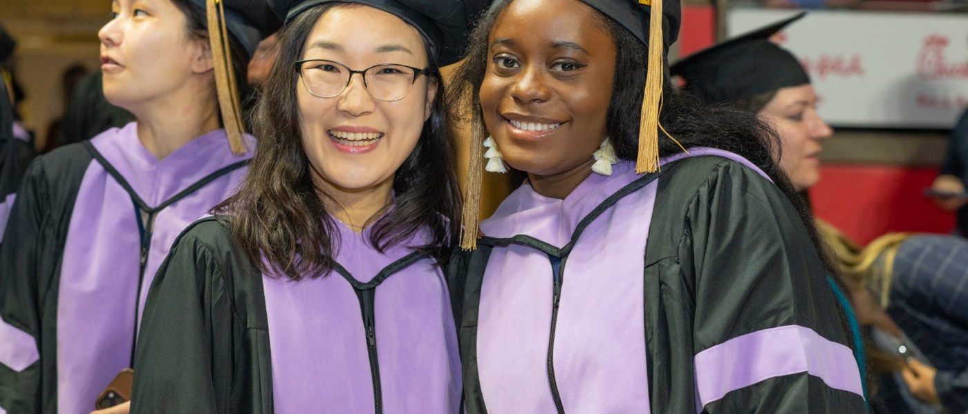 Two graduates pose for a photo