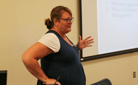 teacher standing in front of screen teaching